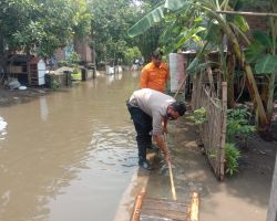 Antisipasi Banjir, Bhabinkamtibmas Polres Mojokerto Bersama Warga Bersihkan Saluran Air 