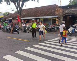 Polisi Lalulintas Membantu Masyarakat Menyebrang Jalan
